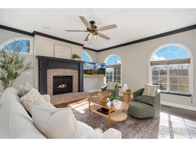 a living room with furniture a fireplace and a ceiling fan
