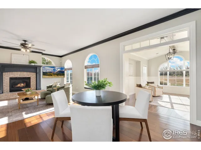 a view of a dining room with furniture a fireplace and wooden floor