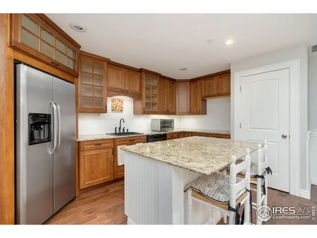 a kitchen with stainless steel appliances granite countertop a sink refrigerator and cabinets