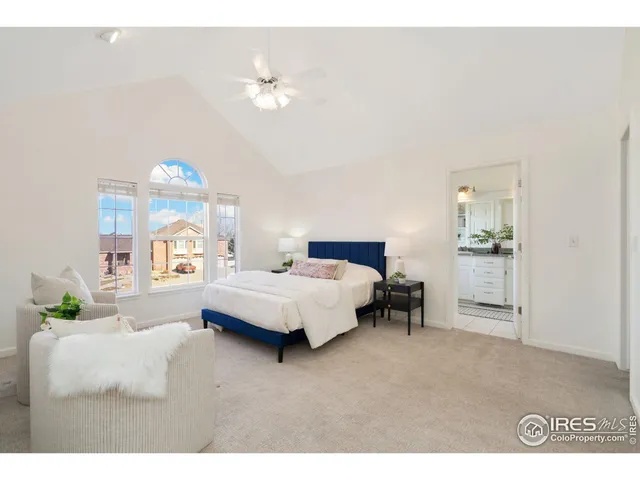 a spacious bedroom with a bed and a chandelier