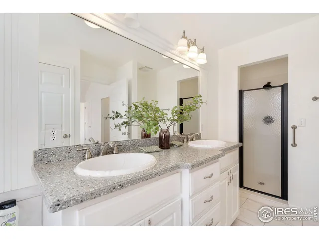 a bathroom with a granite countertop sink a mirror and a shower