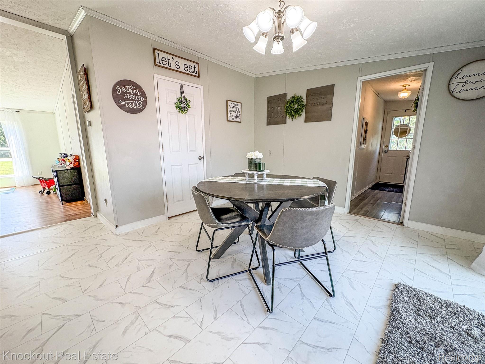 7760 Bell Road Birch Run, MI 48415 - Photo 23 of 68 Dining area featuring light gray wall paneling and white patterned tile flooring