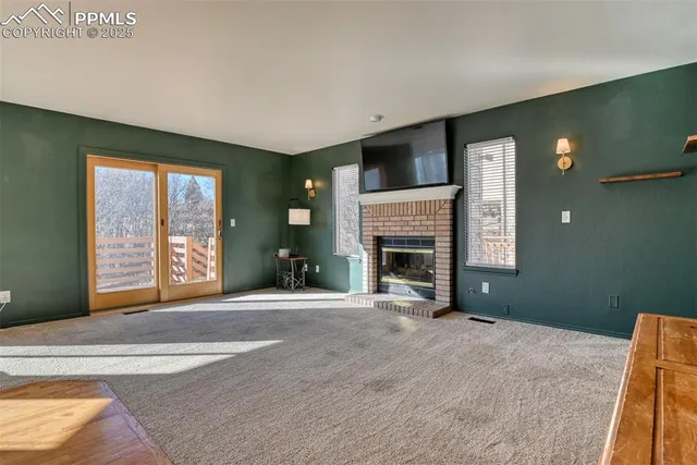 a view of an empty room with window and fire place