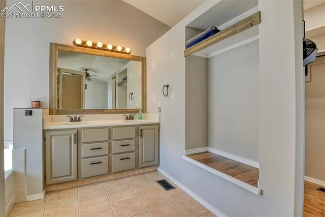 a spacious bathroom with a double vanity sink mirror and bathtub