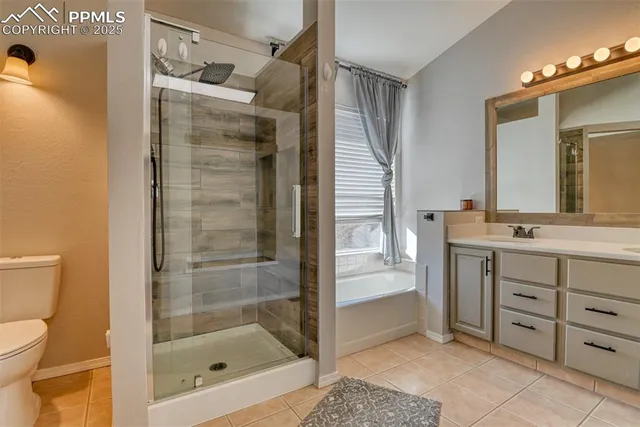 a bathroom with a granite countertop sink a toilet and shower