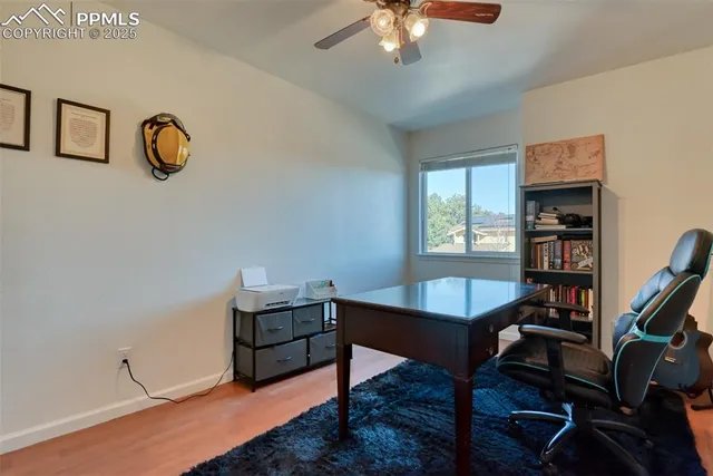 a view of a workspace with furniture and a window