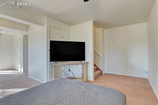 a spacious bedroom with a large bed and a chandelier