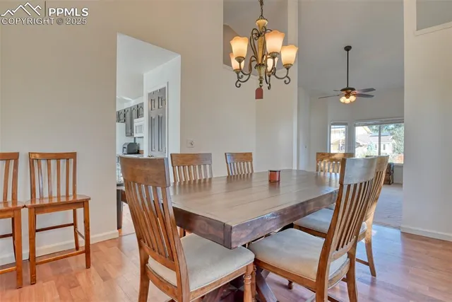 a view of a dining room with furniture a chandelier and wooden floor