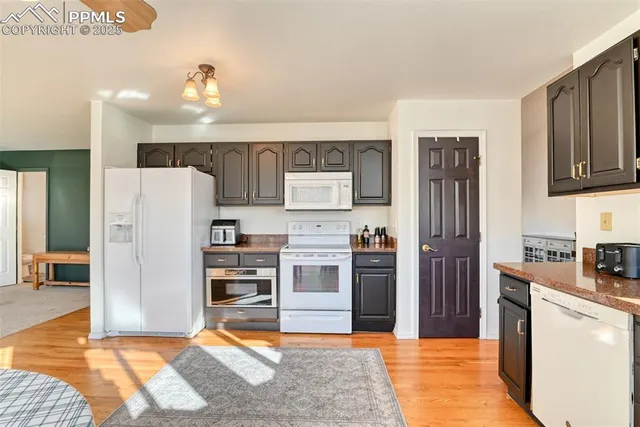 a kitchen with granite countertop a refrigerator and a stove top oven