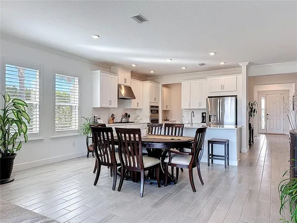 a dining room with furniture potted plants and wooden floor