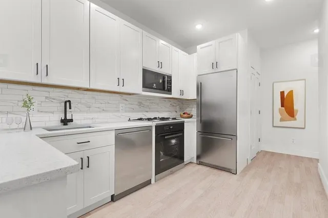 a kitchen with stainless steel appliances a refrigerator sink and cabinets
