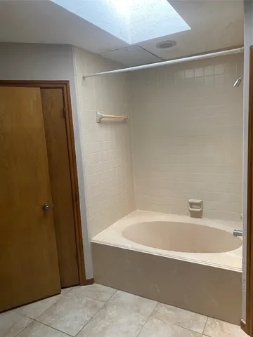 a spacious bathroom with a bathtub and shower