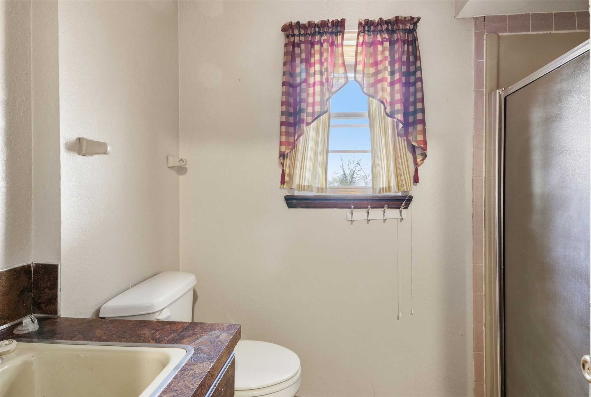 17875 East 589 Road Inola, OK 74036 - Photo 66 of 73 White toilet, window with wood trim, and a built-in shower enclosure just off the mud room
