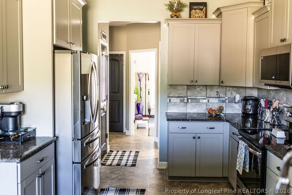 210 McGougan Road Lumber Bridge, NC 28357 - Photo 12 of 47 a kitchen with stainless steel appliances granite countertop a refrigerator sink and white cabinets