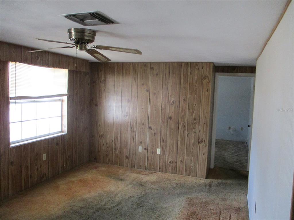 7403 Heather Street New Port Richey, FL 34653 - Photo 13 of 16 en empty room with windows and fan