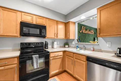 a kitchen with stainless steel appliances white cabinets and a stove top oven