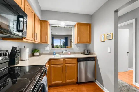 a kitchen with stainless steel appliances granite countertop a stove a sink and a microwave