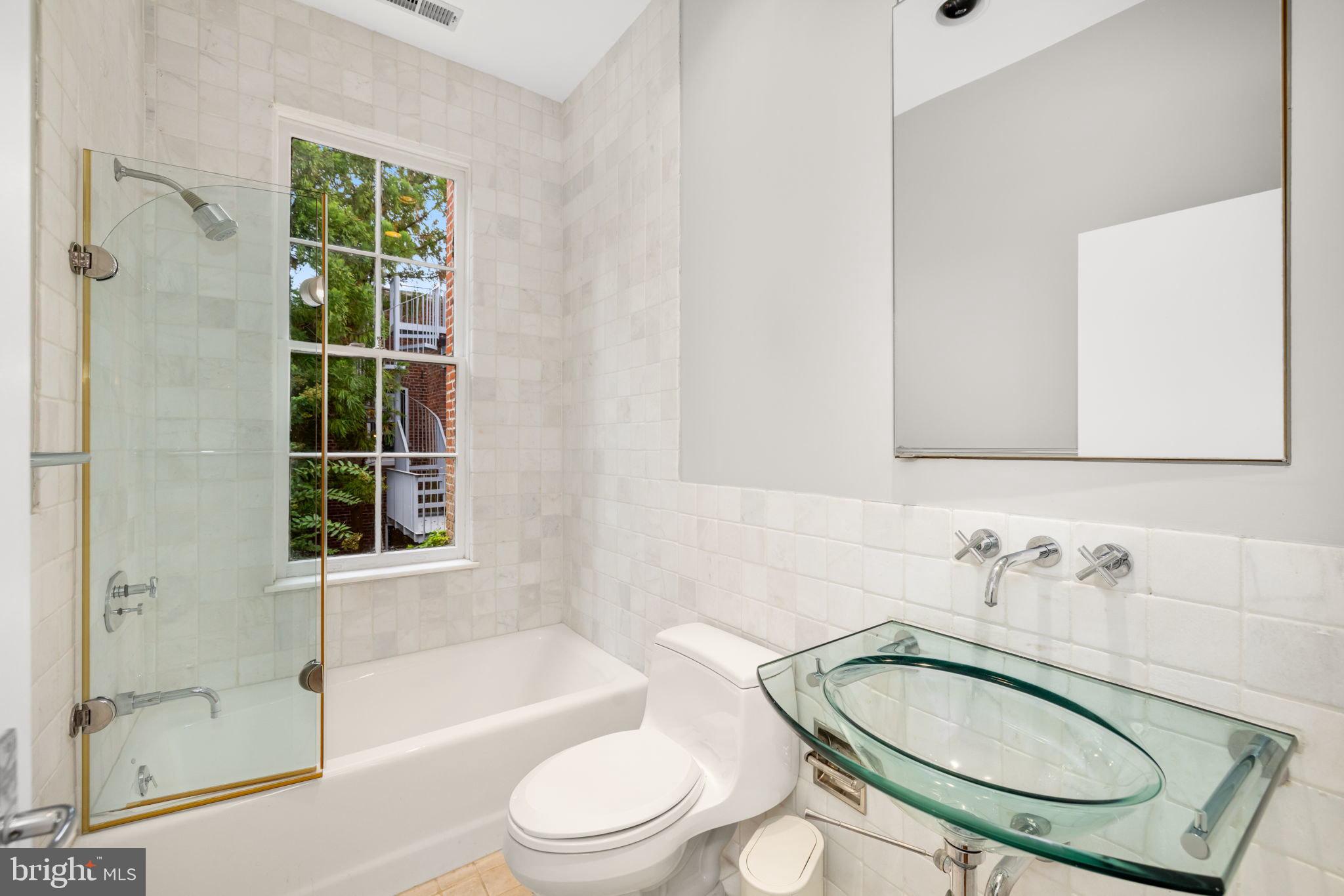 2813 Q Street Northwest Washington, DC 20007 - Photo 11 of 22 a bathroom with a granite countertop toilet a sink and a bathtub
