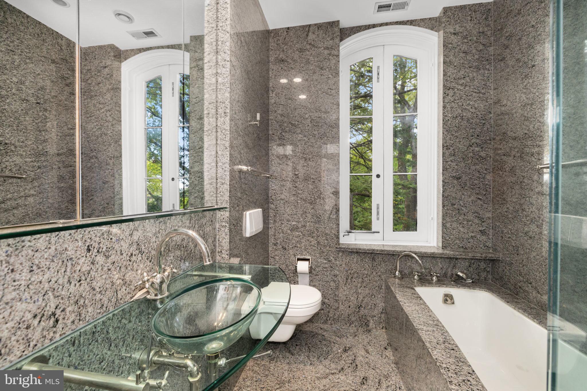 2813 Q Street Northwest Washington, DC 20007 - Photo 13 of 22 a bathroom with a granite countertop tub a sink and a large mirror