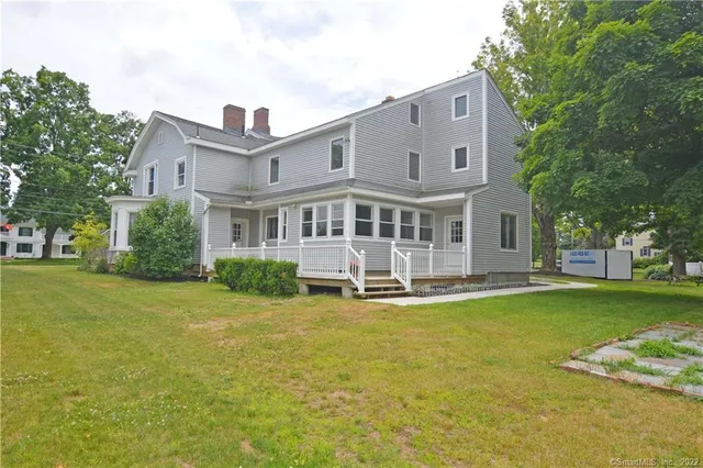 a front view of a house with swimming pool having outdoor seating