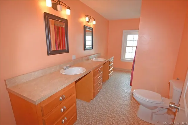 a spacious bathroom with a granite countertop sink mirror vanity and toilet