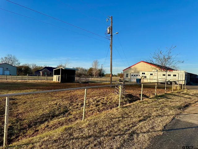 a view of a big house with a big yard and large trees