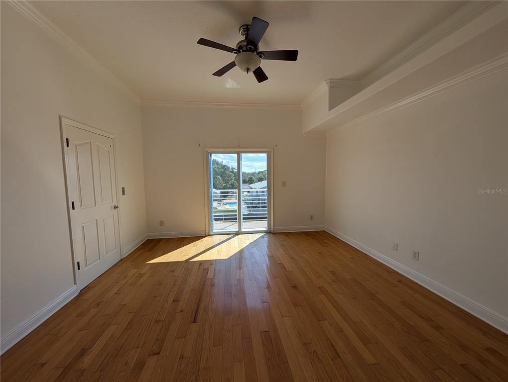 7436 Islander Lane Hudson, FL 34667 - Photo 18 of 27 a view of empty room with wooden floor and fan