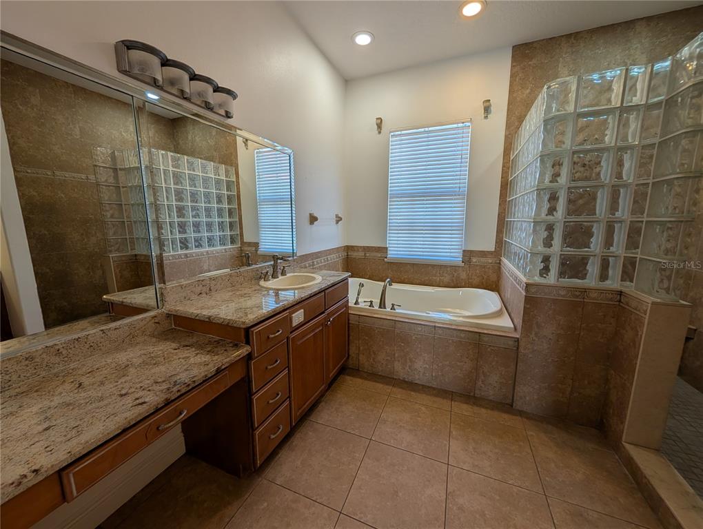 7436 Islander Lane Hudson, FL 34667 - Photo 19 of 27 a bathroom with a granite countertop bathtub sink and mirror