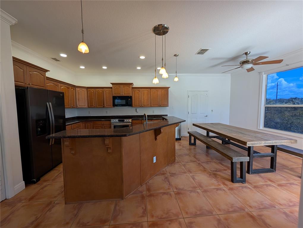 7436 Islander Lane Hudson, FL 34667 - Photo 6 of 27 a kitchen with stainless steel appliances granite countertop a stove a sink and a refrigerator