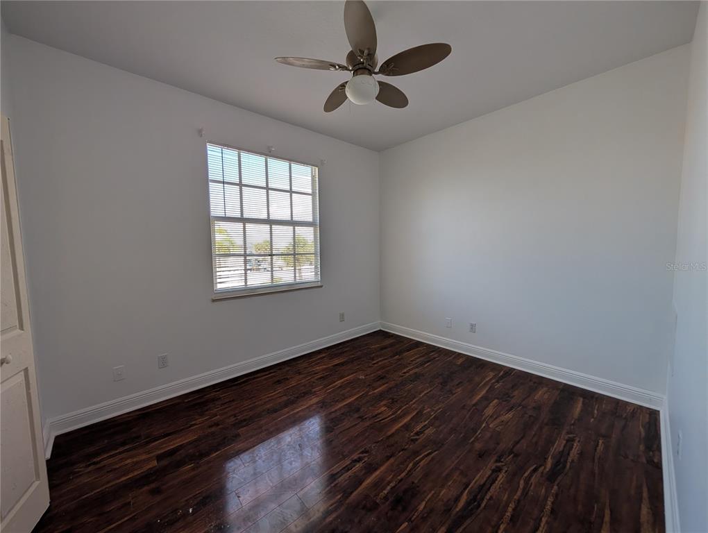 7436 Islander Lane Hudson, FL 34667 - Photo 10 of 27 wooden floor in an empty room with a window