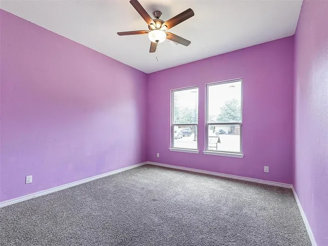 a big room with windows and chandelier fan