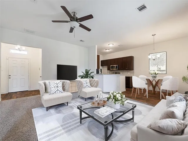 a living room with furniture kitchen view and a flat screen tv