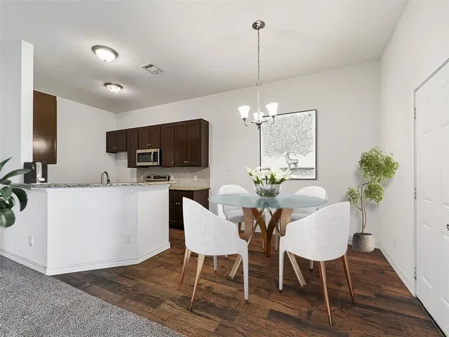a view of a dining room and livingroom with furniture wooden floor a chandelier