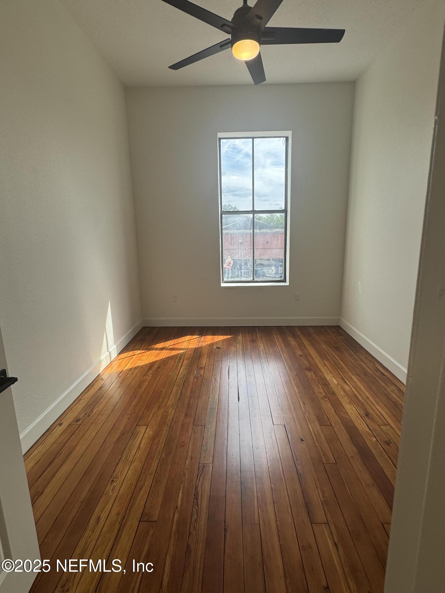 115 East Call Street Starke, FL 32091 - Photo 8 of 11 an empty room with wooden floor and windows