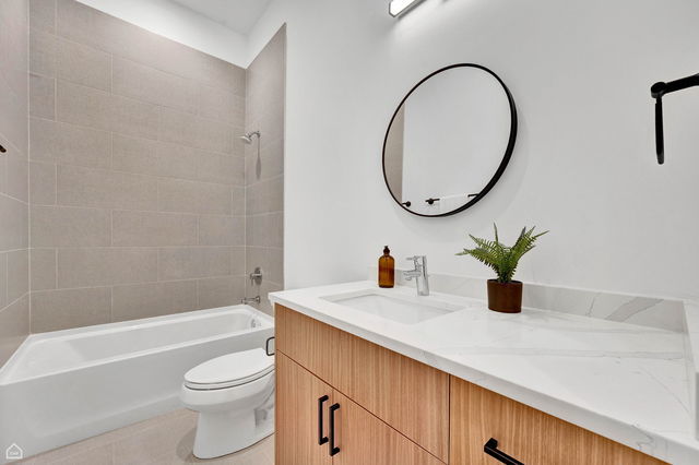 1616 West Hastings Street, Unit 101 Chicago, IL 60608 - Photo 15 of 19 a bathroom with a granite countertop sink a toilet and a mirror