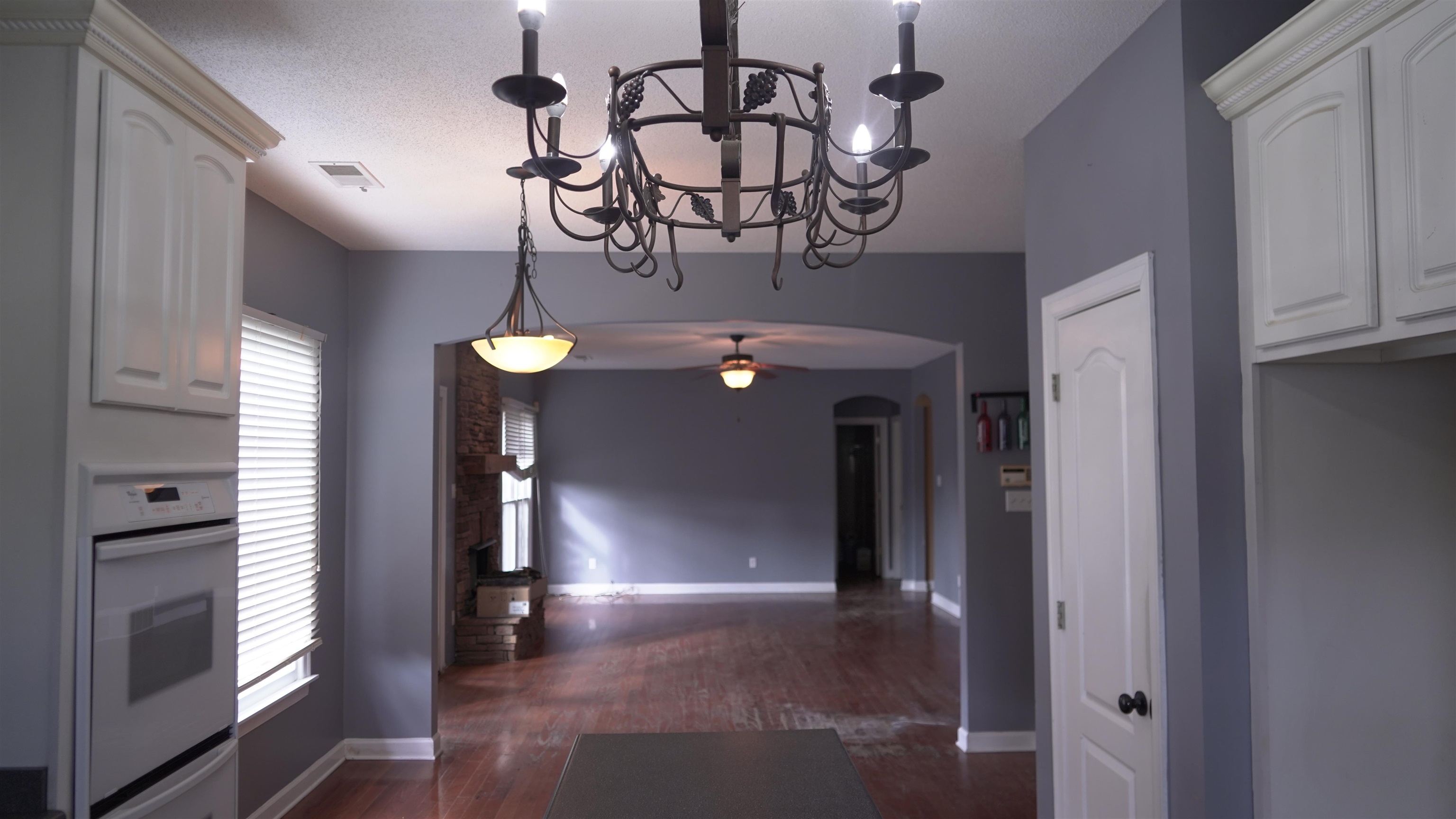3717 Meade Lake Road Millington, TN 38053 - Photo 16 of 16 Kitchen with arched walkways, white cabinets, white oven, open floor plan, and dark wood-style floors