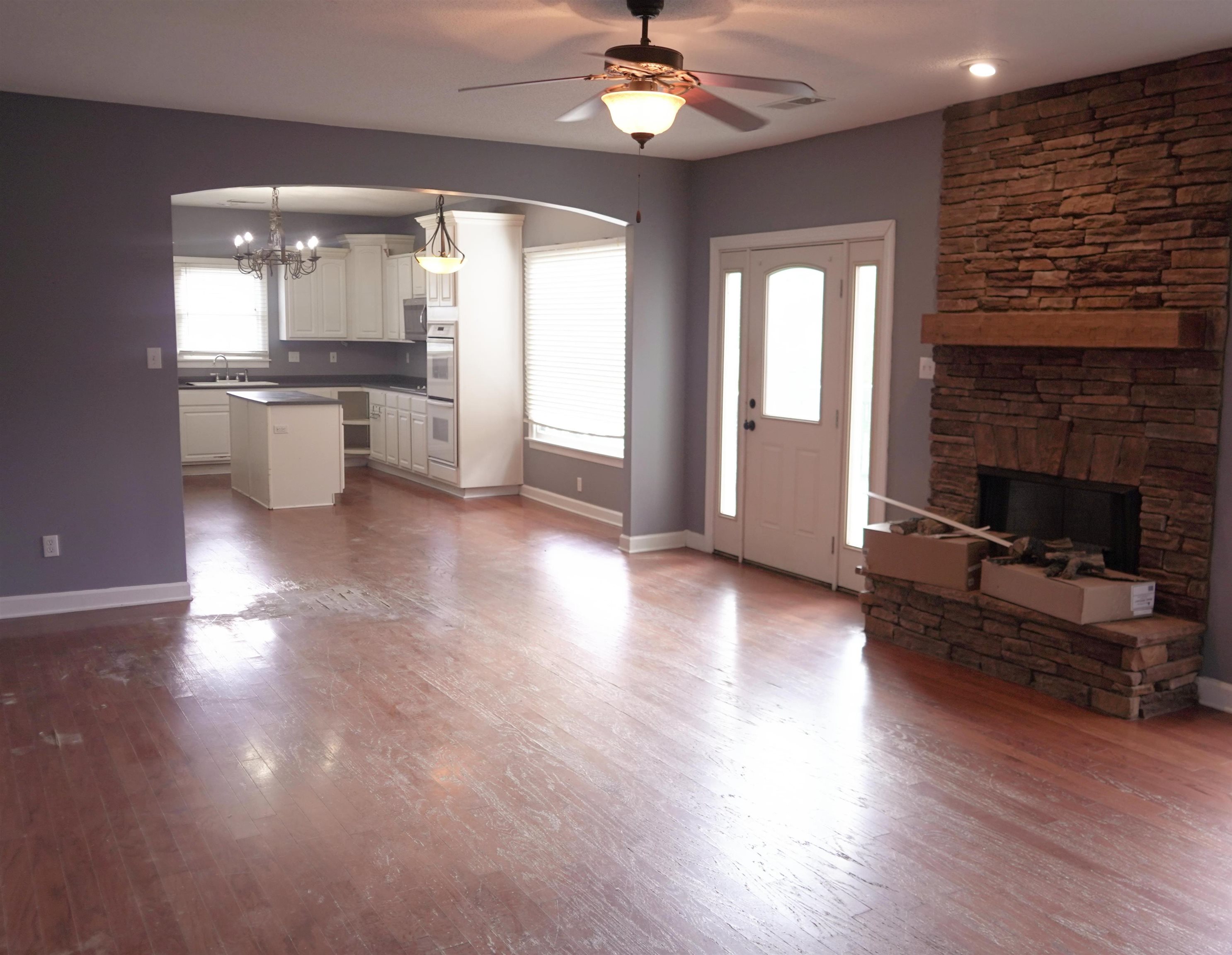 3717 Meade Lake Road Millington, TN 38053 - Photo 6 of 16 Unfurnished living room featuring arched walkways, dark wood finished floors, ceiling fan, and suspended lighting