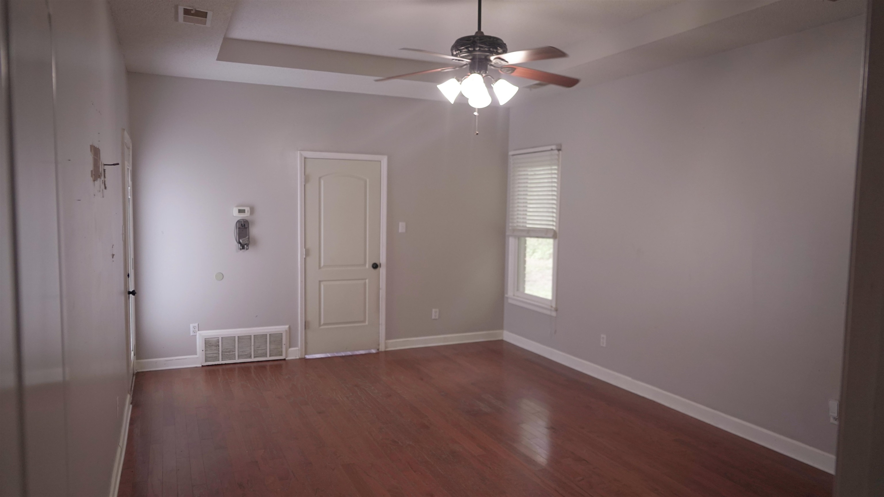 3717 Meade Lake Road Millington, TN 38053 - Photo 8 of 16 Empty room featuring dark wood-style flooring, ceiling fan, and a raised ceiling