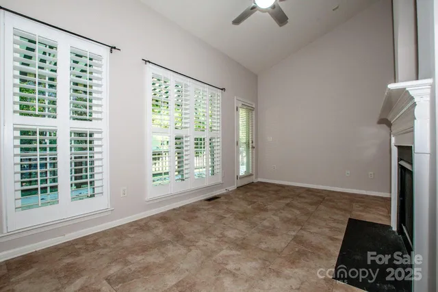 a view of an empty room with a window and a ceiling fan