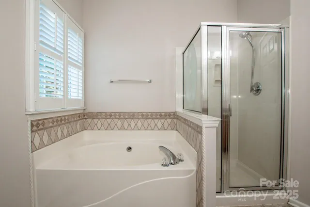 a white bath tub sitting next to a shower