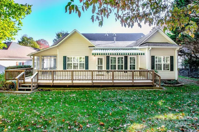 a view of a house with a yard and deck
