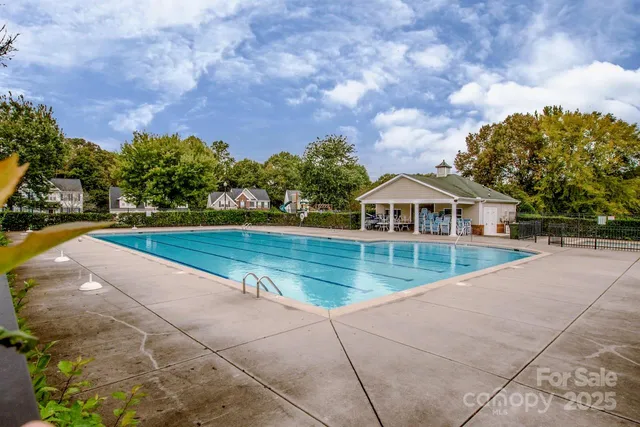 a view of house with swimming pool and green space