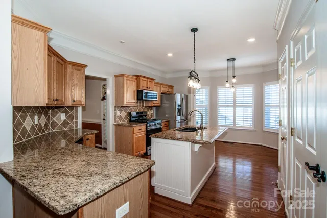a kitchen with stainless steel appliances granite countertop a sink stove and refrigerator