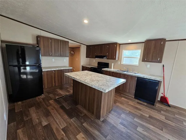 a kitchen with a wooden floor and electronic appliances