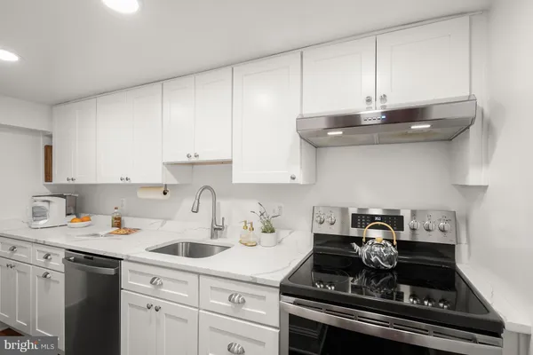 a kitchen with stainless steel appliances granite countertop a sink stove and cabinets