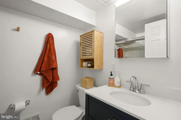a bathroom with a sink vanity and toilet