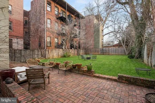 a backyard of a house with barbeque oven table and chairs