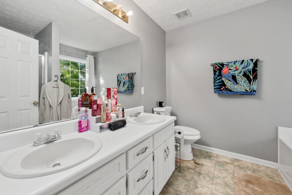 160 Azalea Drive Winder, GA 30680 - Photo 14 of 32 a bathroom with a double vanity sink and a mirror