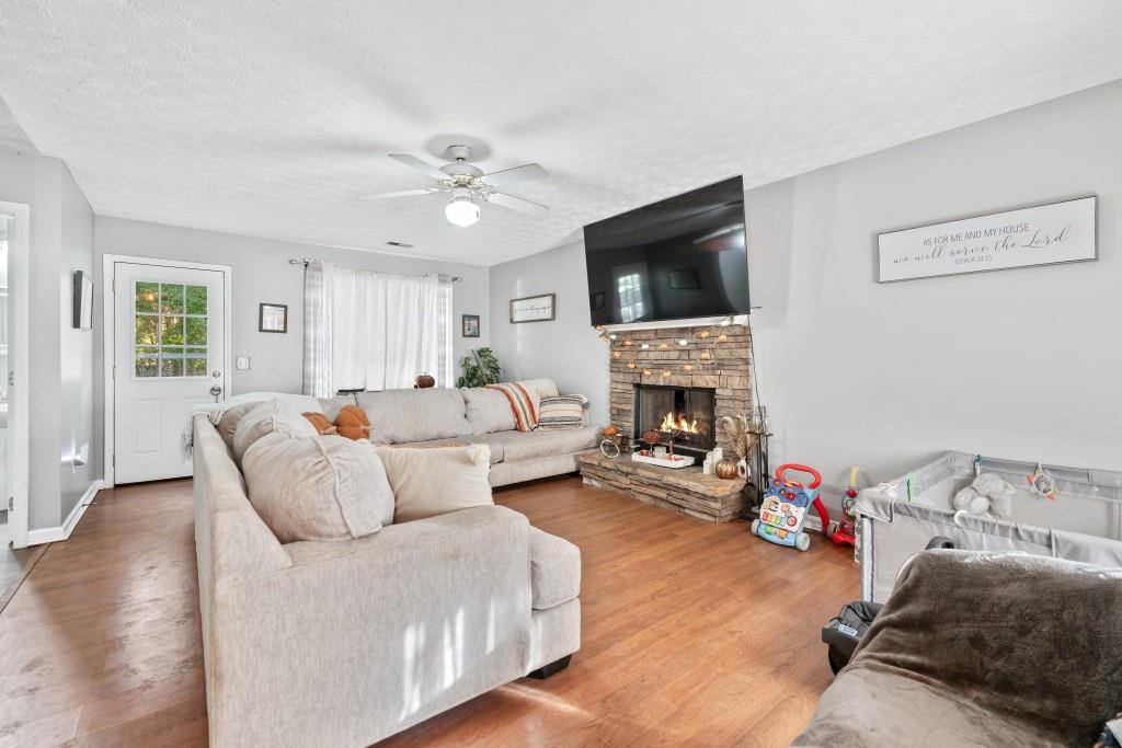 160 Azalea Drive Winder, GA 30680 - Photo 6 of 32 a living room with furniture a flat screen tv and a fireplace