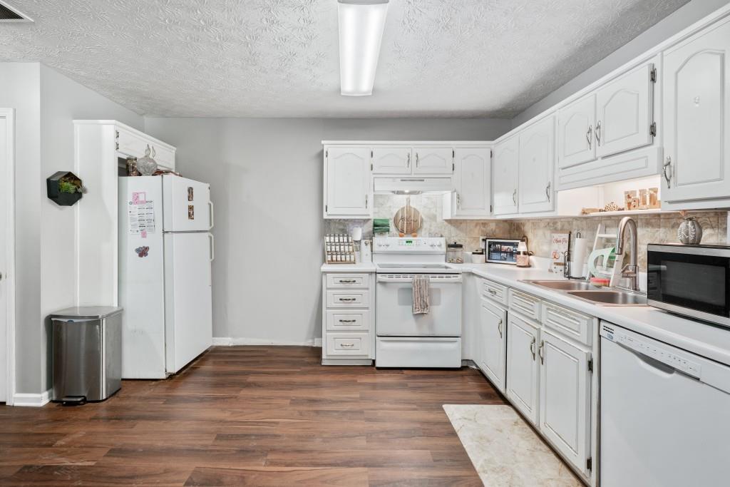 160 Azalea Drive Winder, GA 30680 - Photo 8 of 32 a kitchen with white cabinets and white appliances